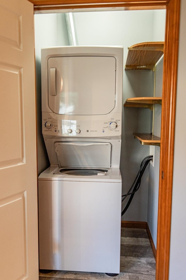 laundry room featuring dark hardwood / wood-style floors and stacked washer / dryer