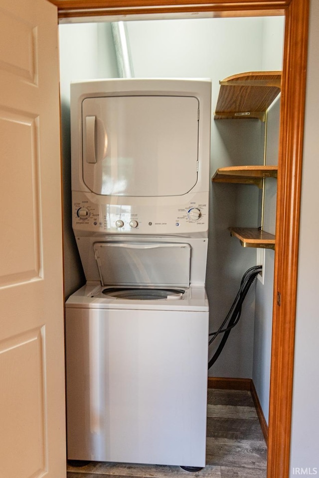 clothes washing area with stacked washer / dryer and dark wood-type flooring