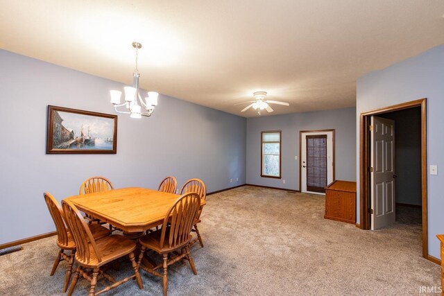 dining room featuring ceiling fan with notable chandelier and light colored carpet