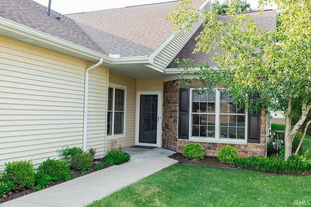 view of exterior entry featuring a lawn