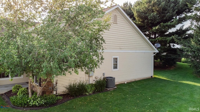 view of property exterior with a yard and central air condition unit