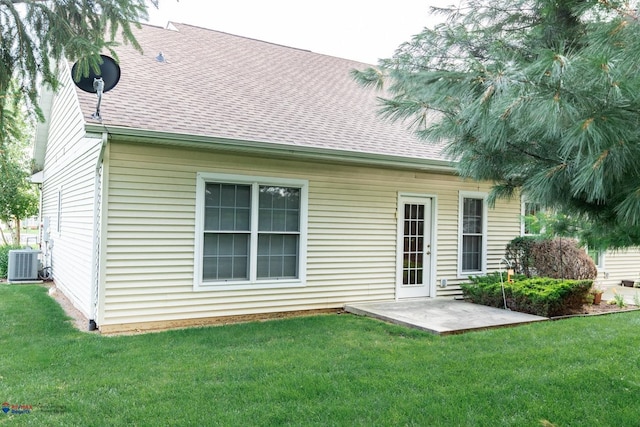 rear view of property with a patio, central AC, and a lawn