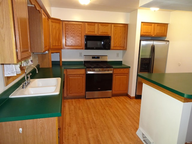 kitchen with light hardwood / wood-style floors, sink, and stainless steel appliances