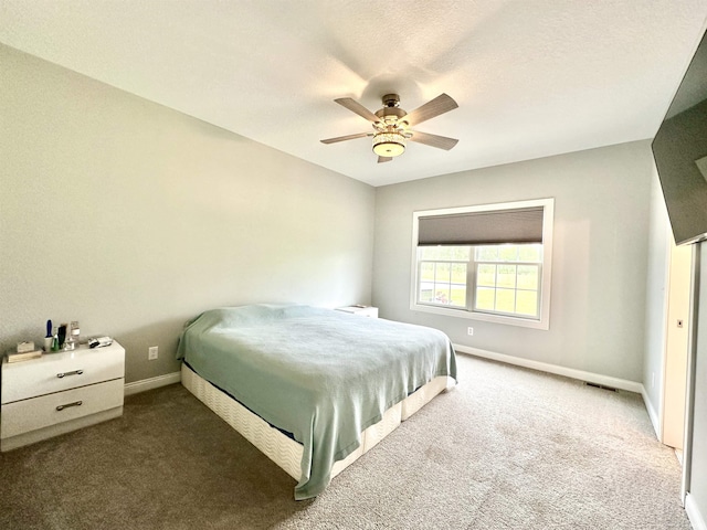 carpeted bedroom featuring ceiling fan and a textured ceiling