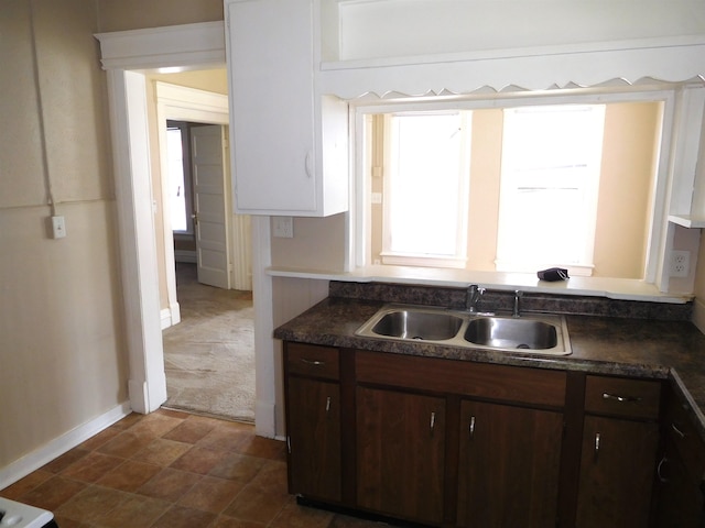 kitchen featuring tile patterned flooring, dark brown cabinets, and sink