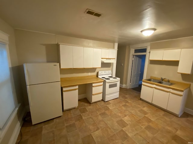 kitchen featuring light tile patterned flooring, white cabinetry, white appliances, and sink