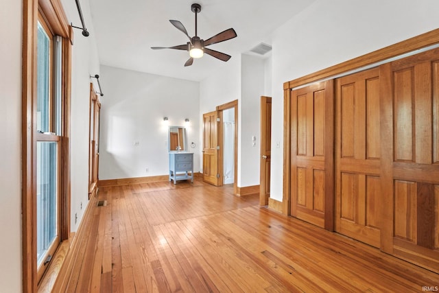 unfurnished bedroom with light wood-type flooring, baseboards, visible vents, and a ceiling fan