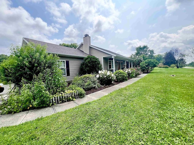 view of side of home featuring a yard and a chimney