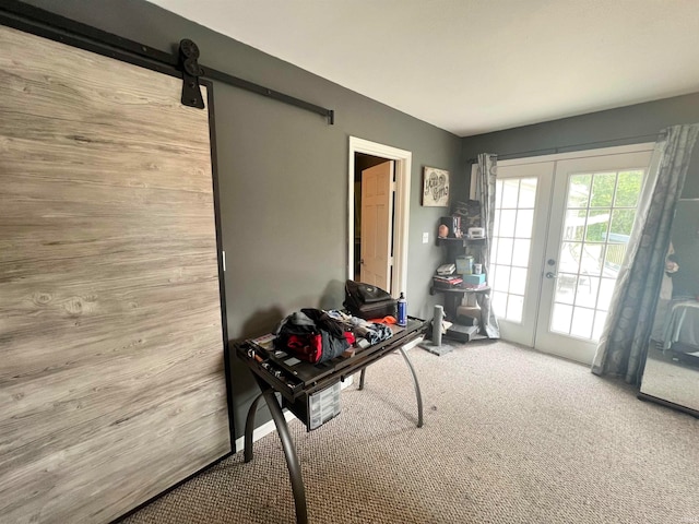 miscellaneous room featuring light carpet, a barn door, and french doors