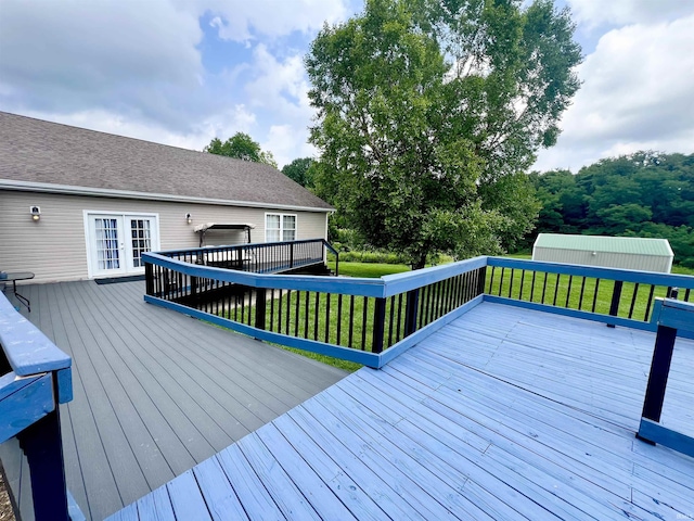 wooden terrace with french doors and a lawn