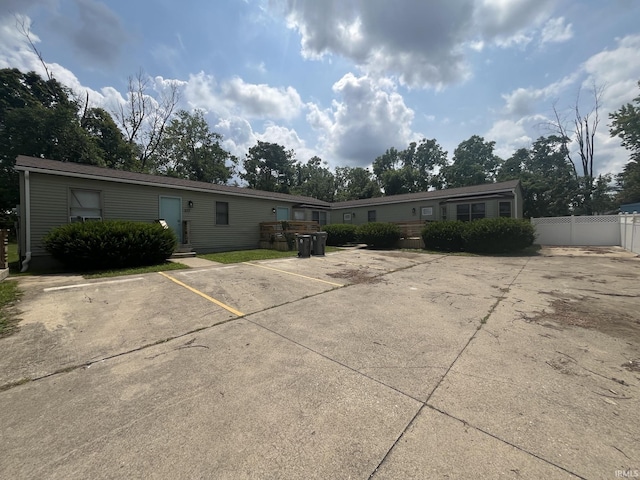 view of front of house featuring uncovered parking and fence