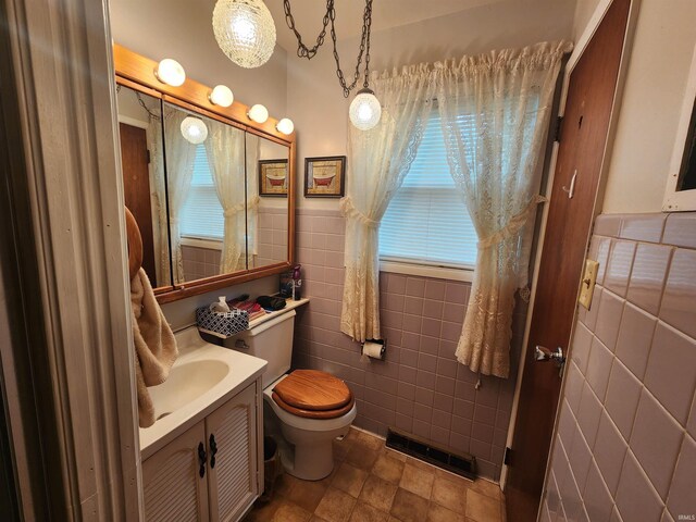 bathroom with tile walls, vanity, and toilet