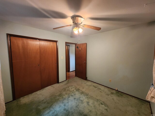 unfurnished bedroom with carpet flooring, ceiling fan, and a closet