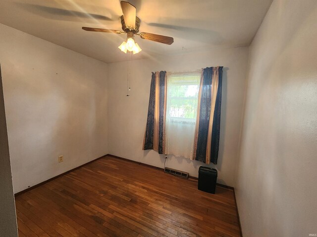 empty room featuring dark hardwood / wood-style flooring and ceiling fan