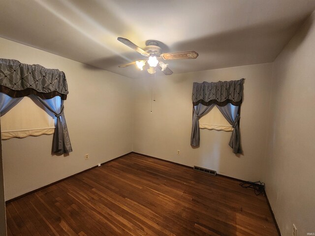 empty room with dark hardwood / wood-style floors and ceiling fan