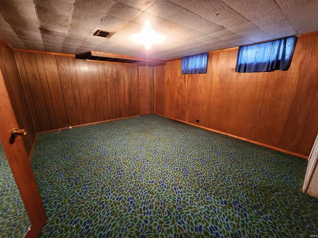 basement with carpet flooring and wooden walls