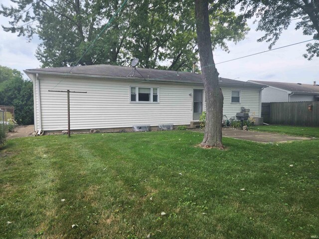 back of property with a yard and a patio area