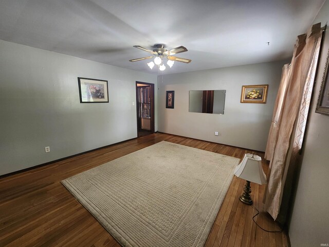 empty room with dark hardwood / wood-style flooring and ceiling fan