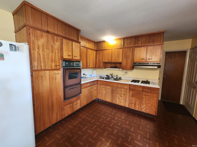 kitchen featuring dark parquet flooring, sink, and white appliances