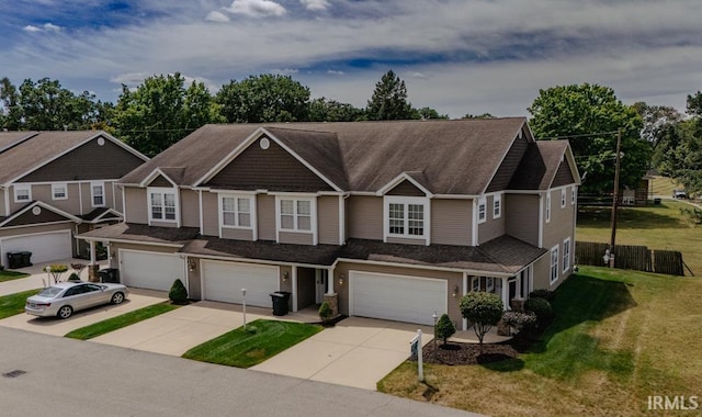 townhome / multi-family property featuring a garage and a front lawn