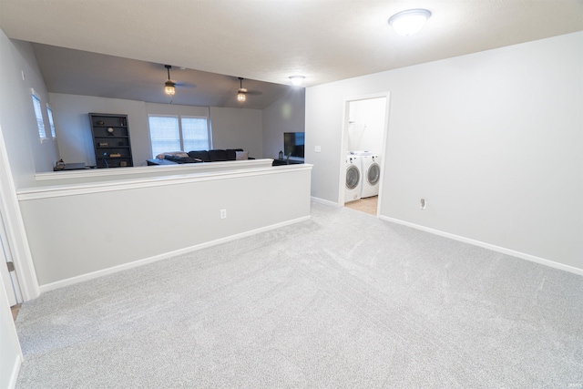 interior space with light carpet, washer and clothes dryer, and ceiling fan