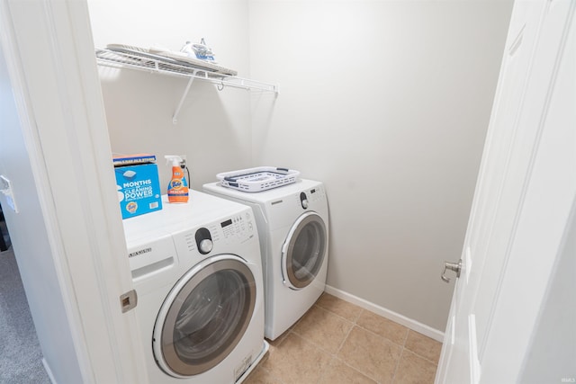 clothes washing area with washer and dryer and light tile patterned floors