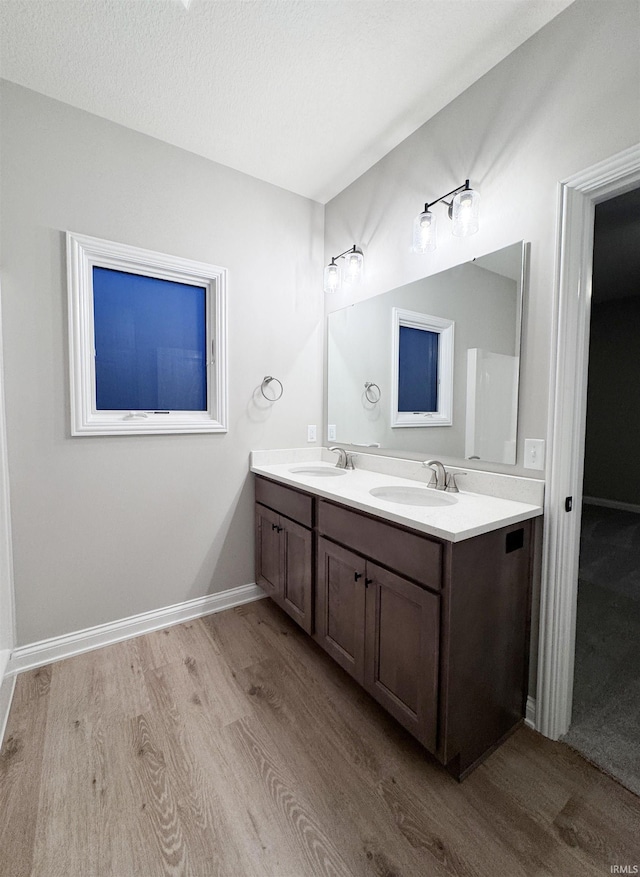 bathroom featuring hardwood / wood-style floors, vanity, and a textured ceiling