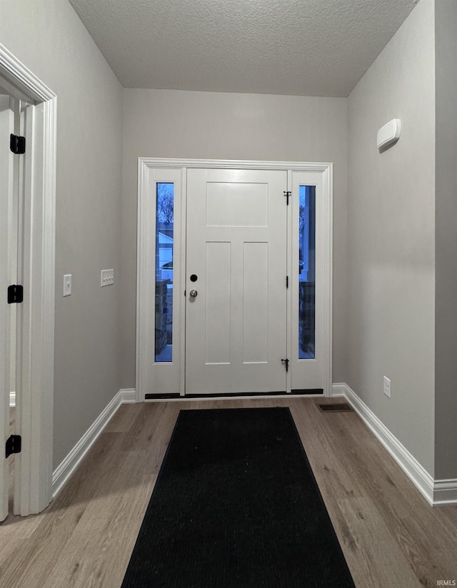 entryway featuring light hardwood / wood-style floors and a textured ceiling