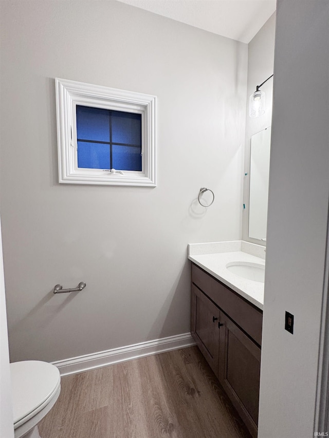 bathroom with hardwood / wood-style floors, vanity, and toilet