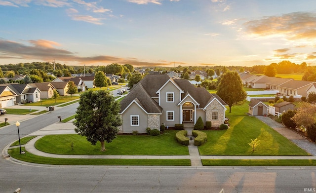 view of front of home with a garage and a lawn