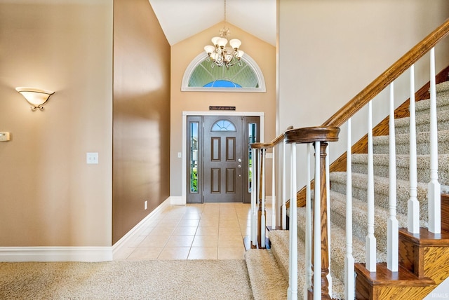 carpeted entryway with a healthy amount of sunlight, a notable chandelier, and high vaulted ceiling