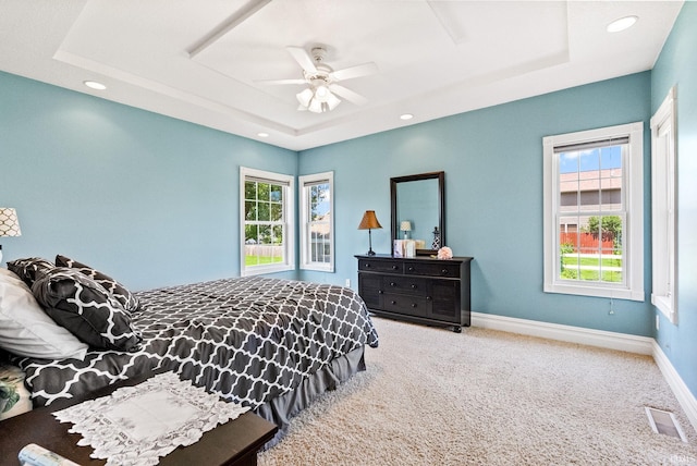 bedroom featuring carpet floors, ceiling fan, and a raised ceiling