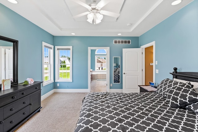 carpeted bedroom featuring ensuite bathroom, ceiling fan, and a raised ceiling