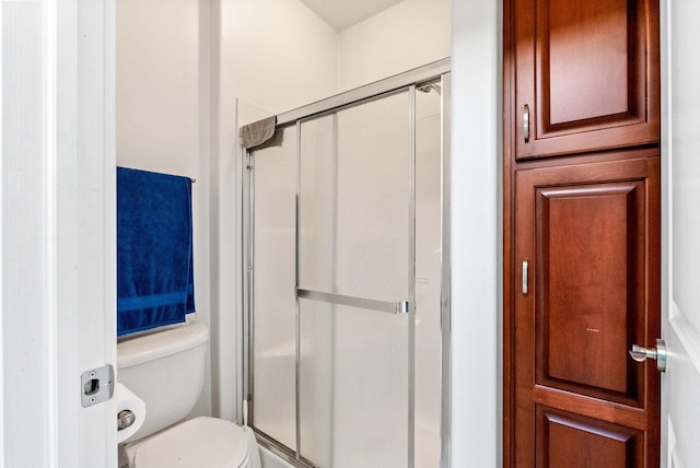 bathroom featuring toilet and an enclosed shower