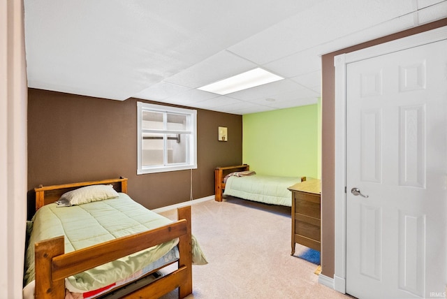 bedroom with carpet floors and a drop ceiling