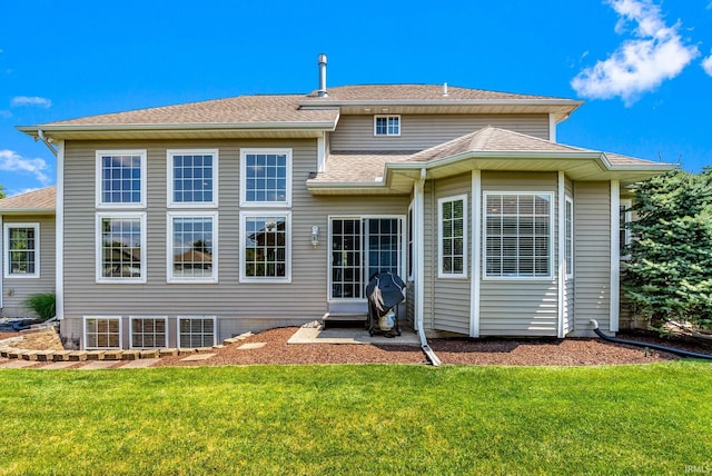 rear view of property featuring a lawn