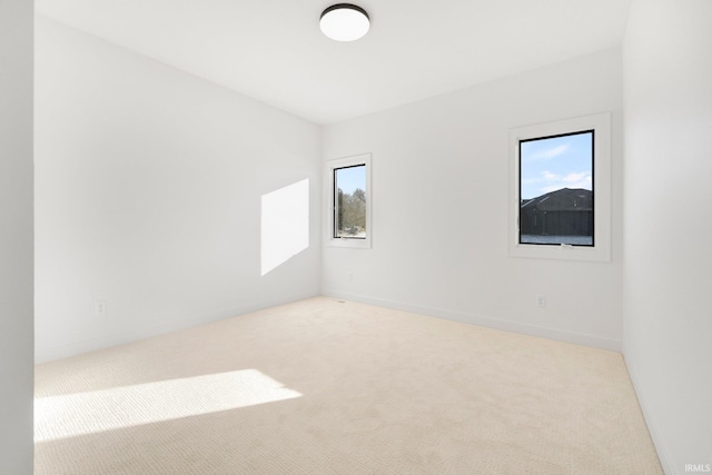 spare room featuring light colored carpet