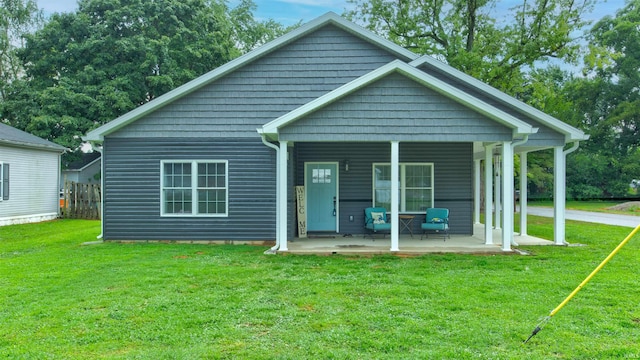 rear view of house featuring a yard