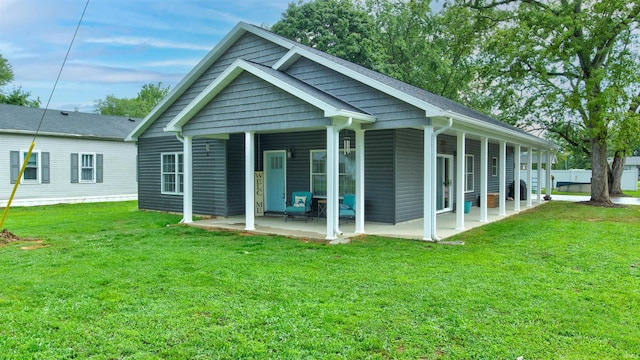 back of property featuring a lawn and a patio area