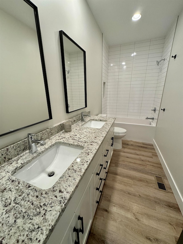 full bathroom with vanity, toilet, tiled shower / bath combo, and wood-type flooring