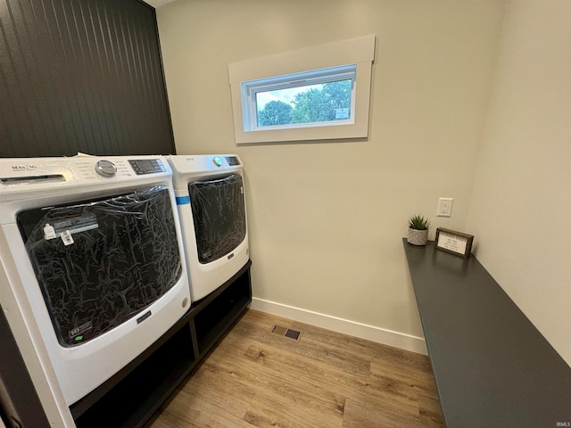 washroom with light wood-type flooring and washing machine and clothes dryer