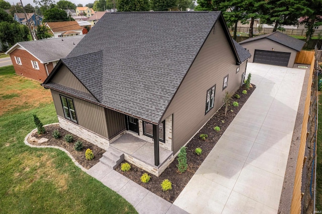 view of front of property featuring a garage, a front lawn, and an outbuilding