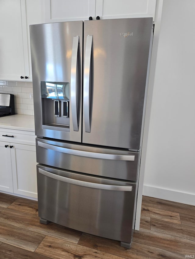 interior details featuring white cabinetry, stainless steel fridge with ice dispenser, backsplash, and dark hardwood / wood-style flooring