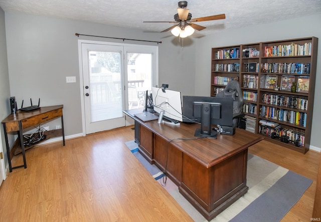 home office with ceiling fan, a textured ceiling, and light hardwood / wood-style flooring