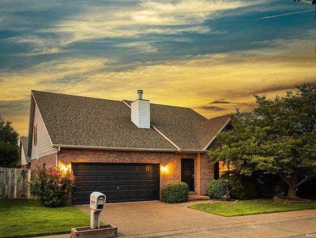 view of front facade with a yard and a garage