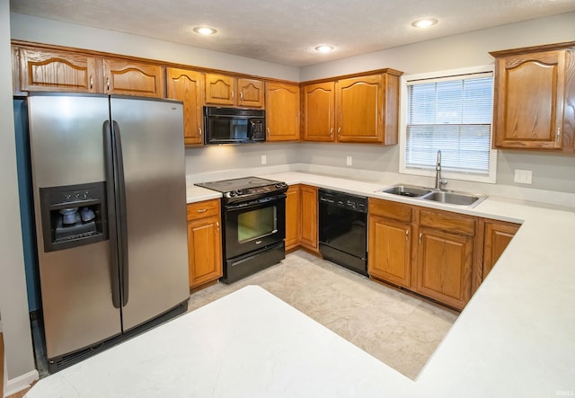 kitchen featuring sink, a textured ceiling, and black appliances