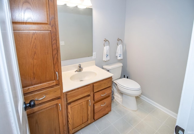 bathroom with tile patterned flooring, vanity, and toilet