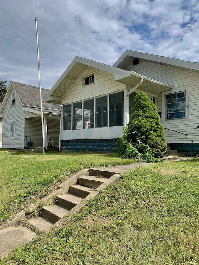 back of house with a yard and a sunroom