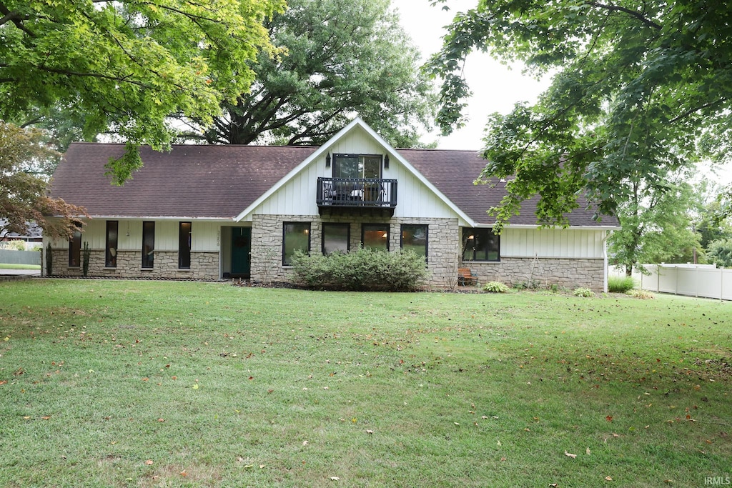 view of front of home featuring a balcony and a front lawn