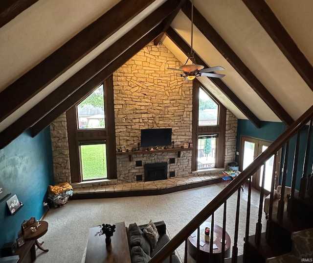 unfurnished living room with beamed ceiling, carpet, and a wealth of natural light